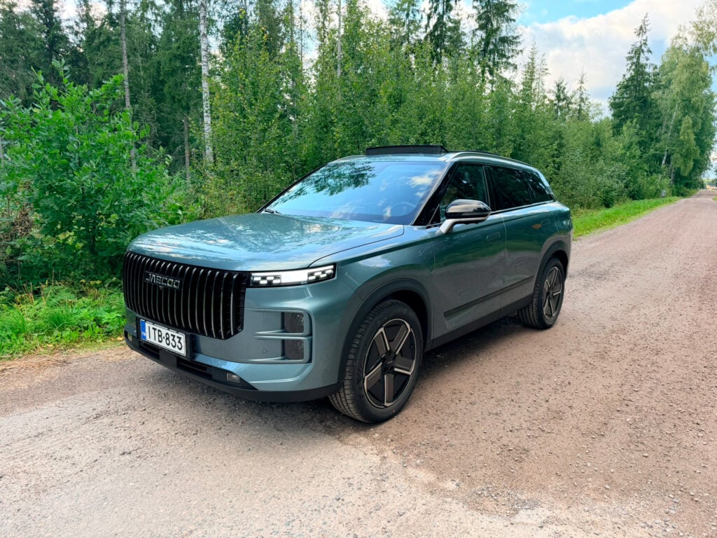 Uusi kiinalainen SUV haastaa hinnalla – myyntiennätyksiä rikkova hybridi maksaa alle 35 000 € Vihreä Jaecoo 7 katumaasturi pysäköitynä metsätiellä Suomessa.