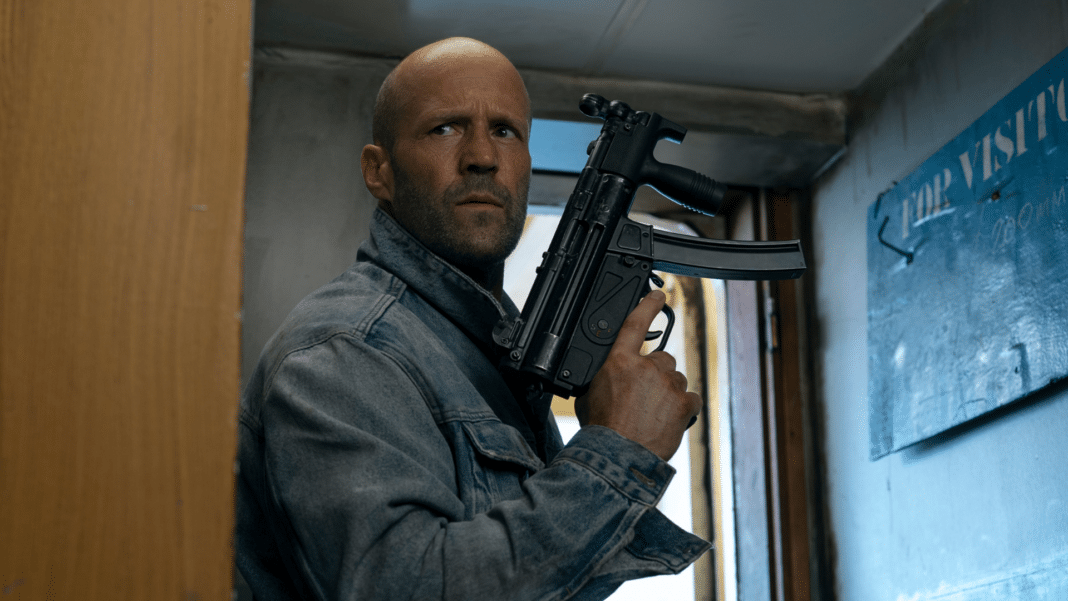 Mutinity arvostelu: Jason Statham konepistooli kädessään rahtilaivan käytävällä Mutiny – Lavastettu syylliseksi -elokuvassa.