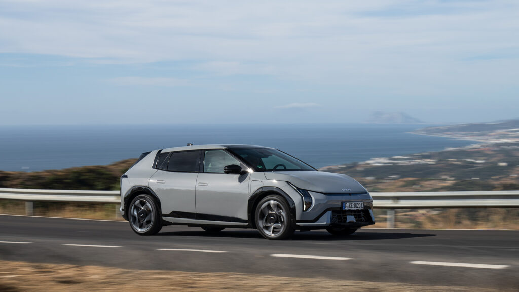 Kia EV4:n saa nyt nelivetona – lisähinta on maltillinen, mutta siitä maksetaan toimintamatkassa Harmaa Kia EV4 GT-Line AWD ajossa vuoristotiellä sivusta kuvattuna.
