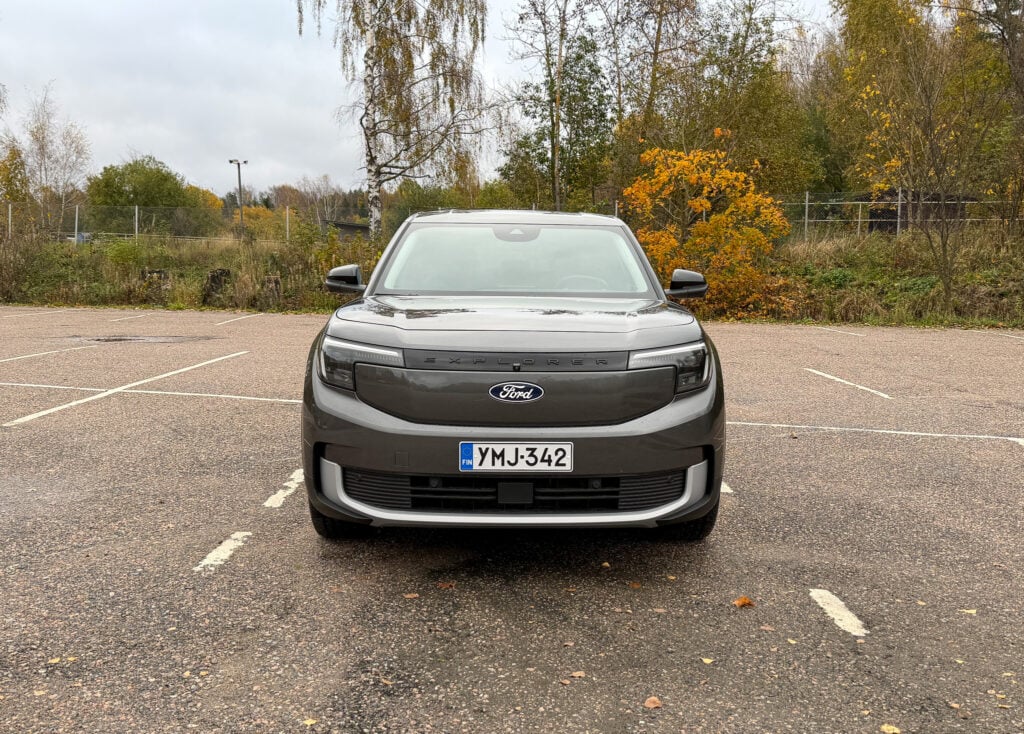 Koeajo: Ford Explorer on pragmaatikon sähköauto – miksi maksaa kilpailijoista enemmän? Harmaan Ford Explorer -sähköauton keula edestä kuvattuna, Fordin logo ja ajovalot näkyvissä.