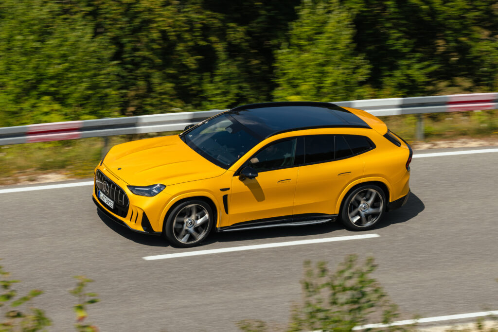 Mercedes-AMG:n ensimmäinen oma sähkö-SUV murisee ja simuloi vaihteenvaihtoja Keltainen Mercedes-AMG GT SUV ajossa kuvattuna yläviistosta.